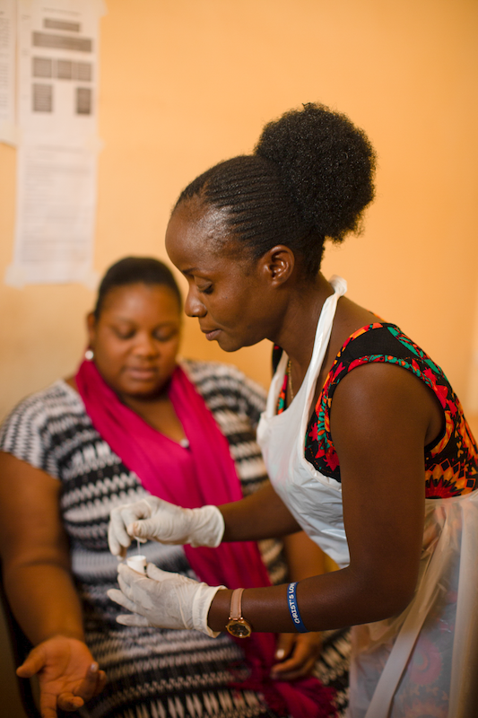 health professional administering covid-19 vaccine to a woman