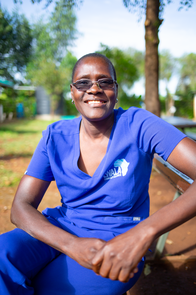 Jane, a mentor mother in Kenya, smiles at the camera